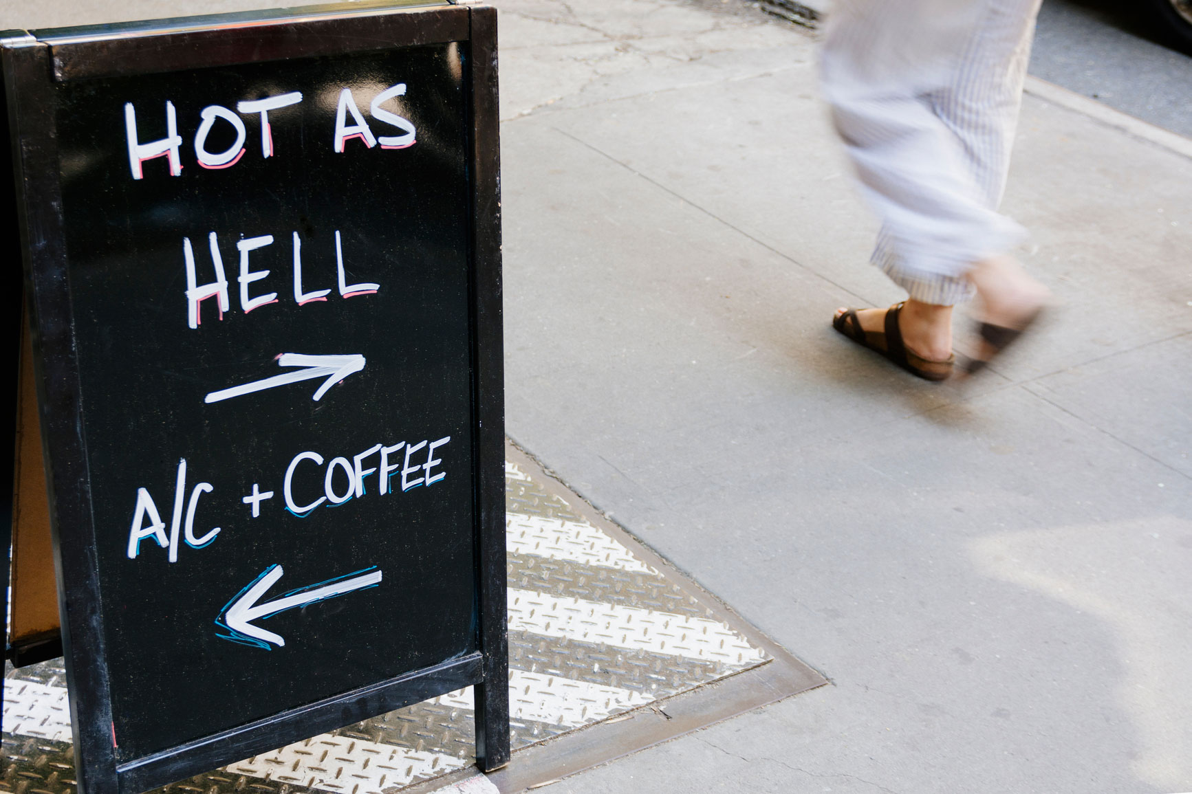 Street sign touting the benefits of AC on a hot day.